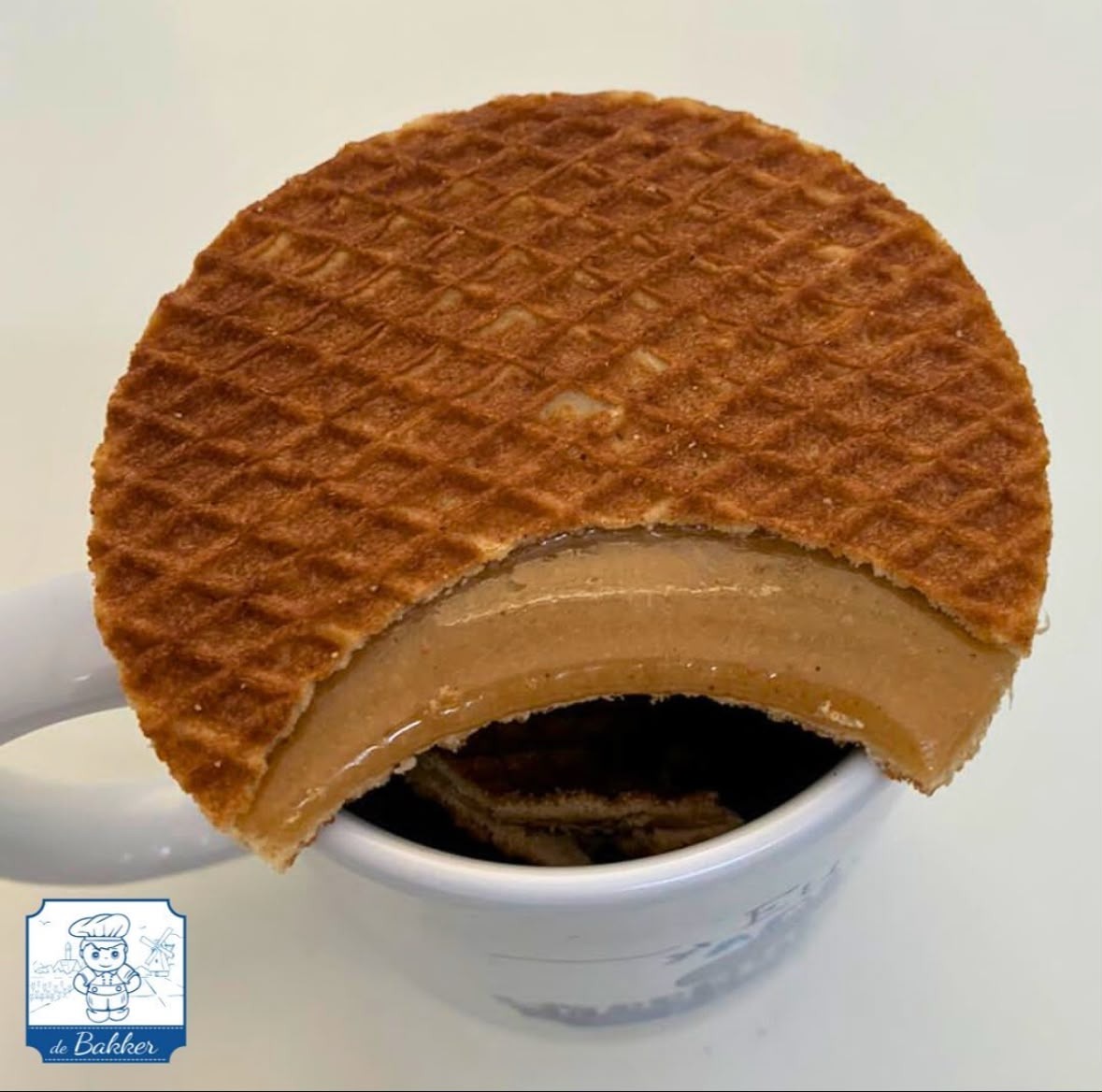 Stroopwafel deBakker sobre uma xícara, mostrando o recheio de caramelo aquecido