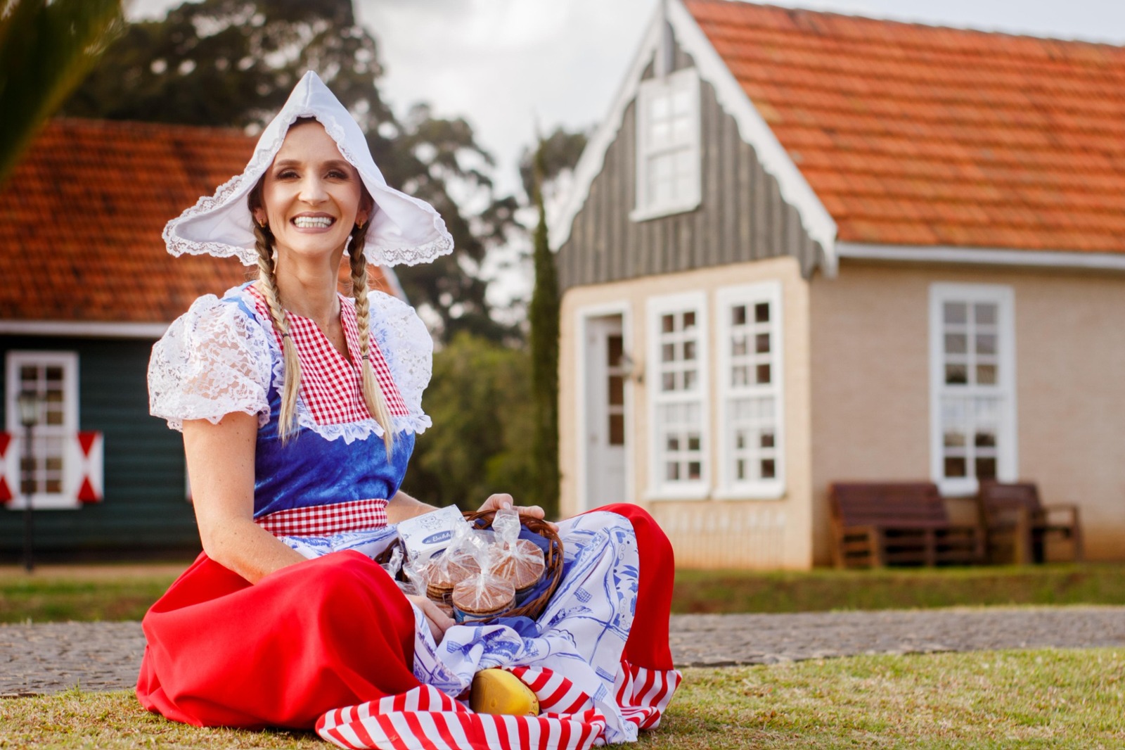 Mulher em traje tradicional holandês com uma cesta de stroopwafels deBakker